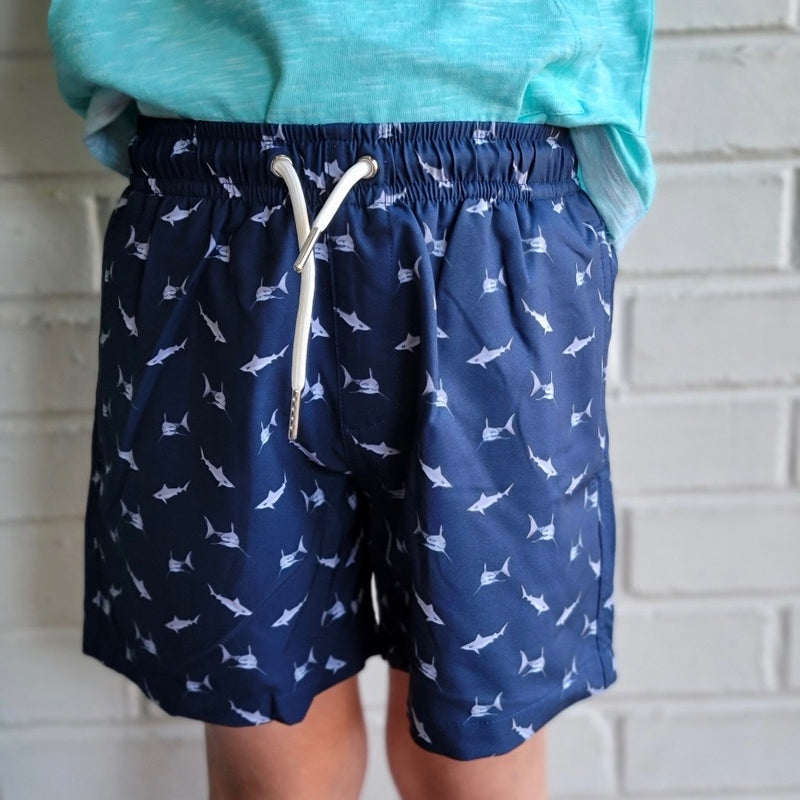 Close up of blue bermies swimming shorts with shark design