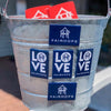 Magnets with “LOVE” on them attached to a metal bucket